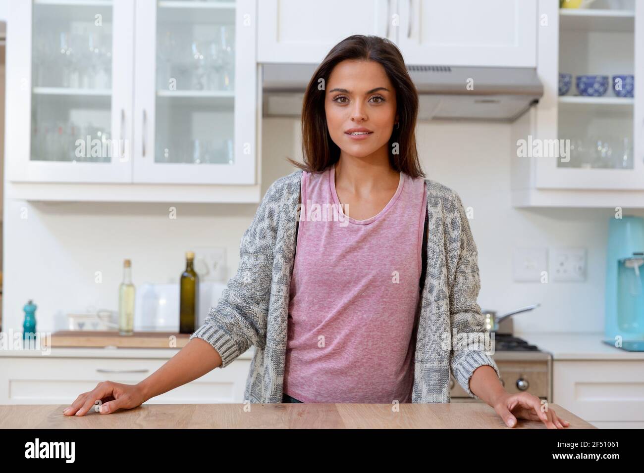 Staning Caucasian woman staning in kitchen looking at camera and smiling Stock ...