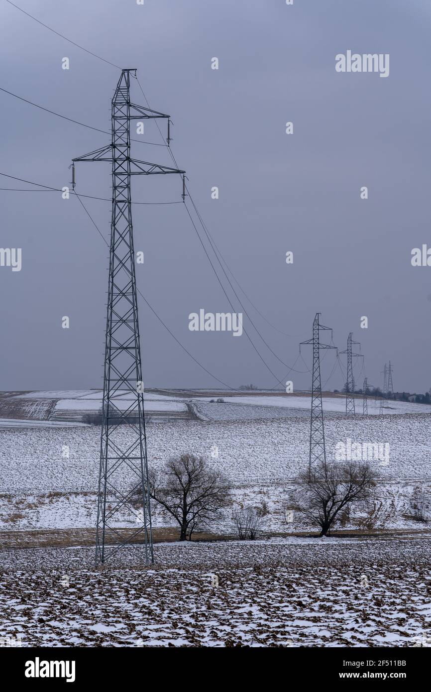 Power pylons crossing farmland in late winter scenery Stock Photo - Alamy