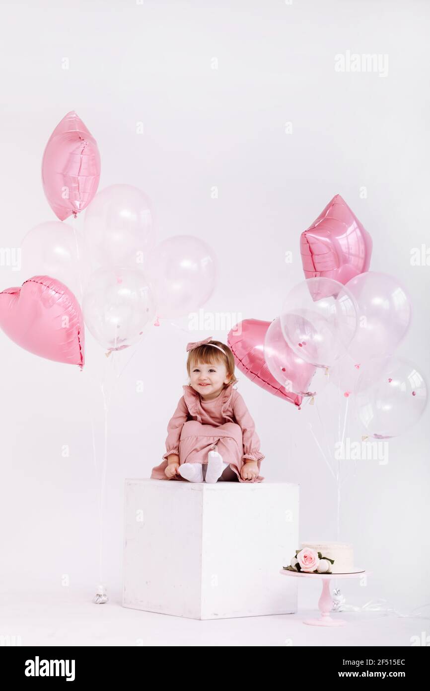 happy birthday 2 years old little girl in pink dress. white cake with ...