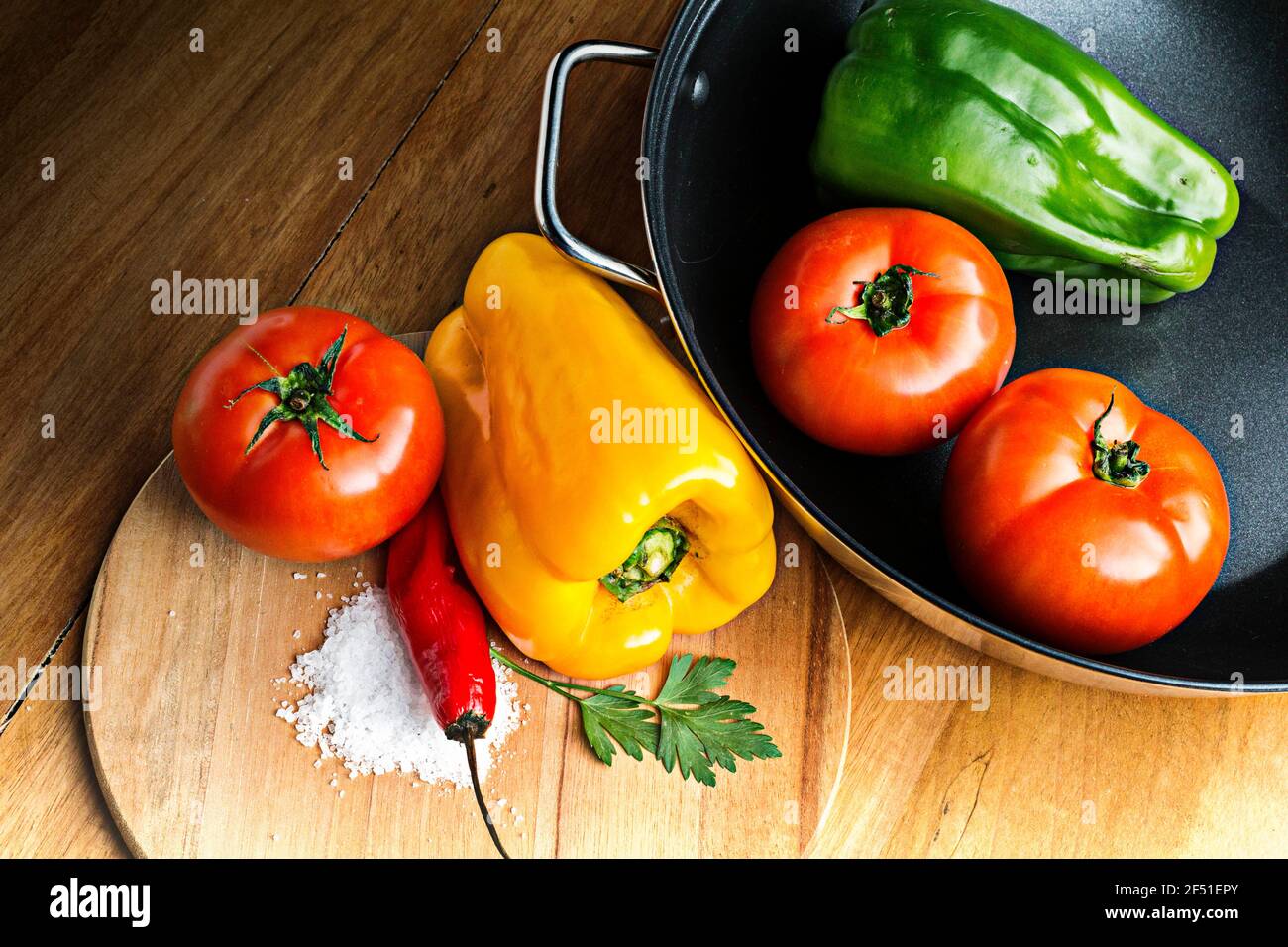 vegetables , tomatos, green papper, yellow papper, red papper, parseley, in the black pan Stock Photo