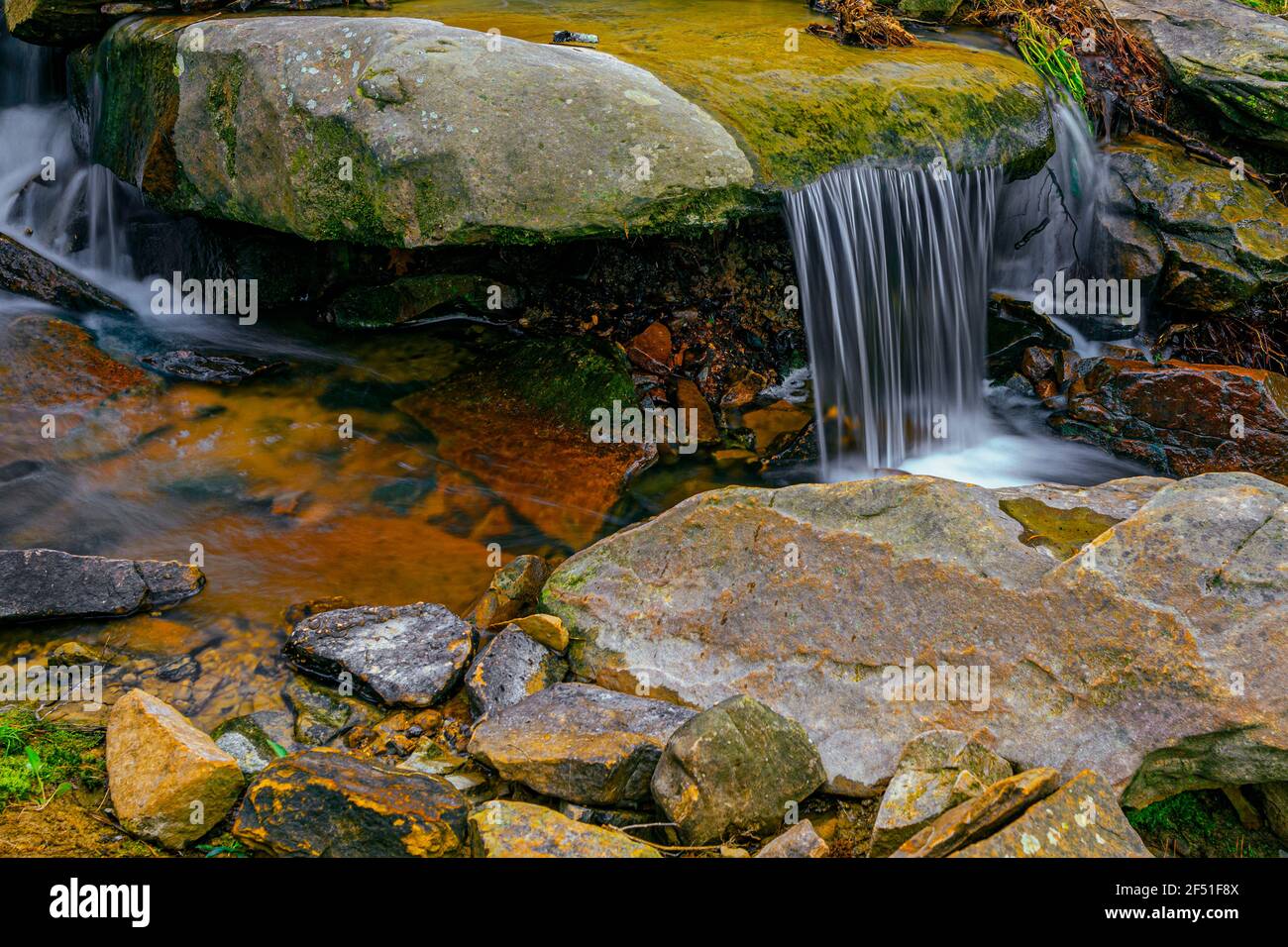 Water flowing over a rock in a creek. Stock Photo