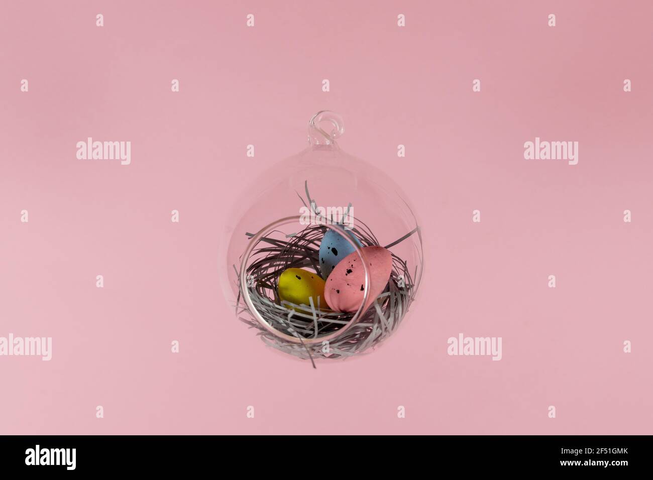 Three eggs in a floating glass nest. Pink background. Creative Easter concept Stock Photo