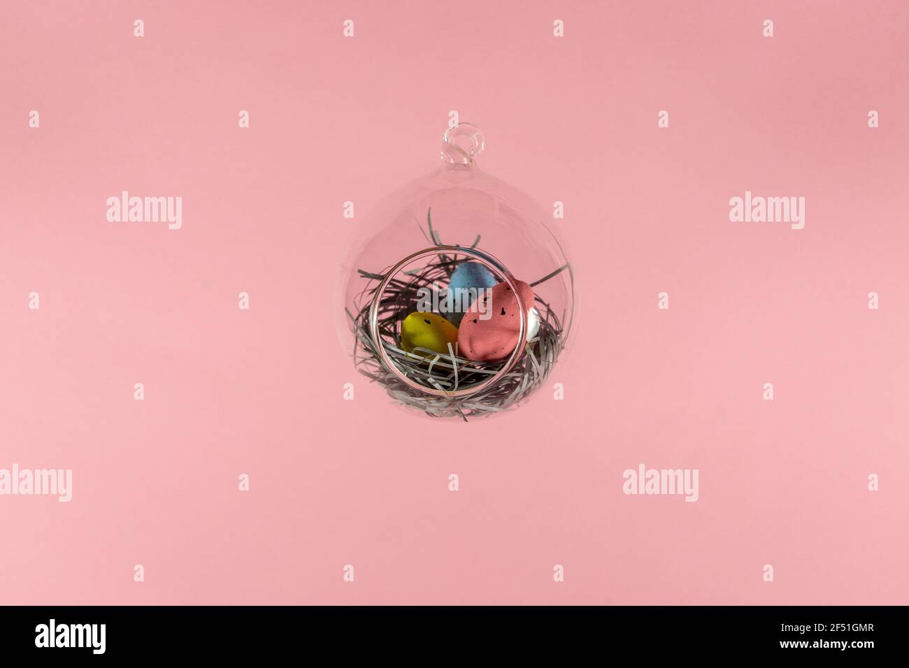 Three eggs in a floating glass nest. Pink background. Creative Easter concept Stock Photo