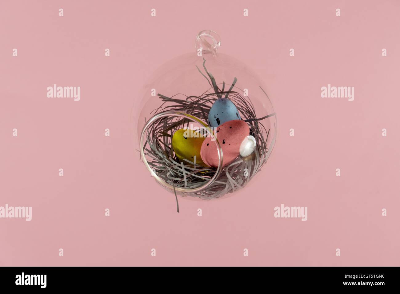 Three eggs in a floating glass nest. Pink background. Creative Easter concept Stock Photo