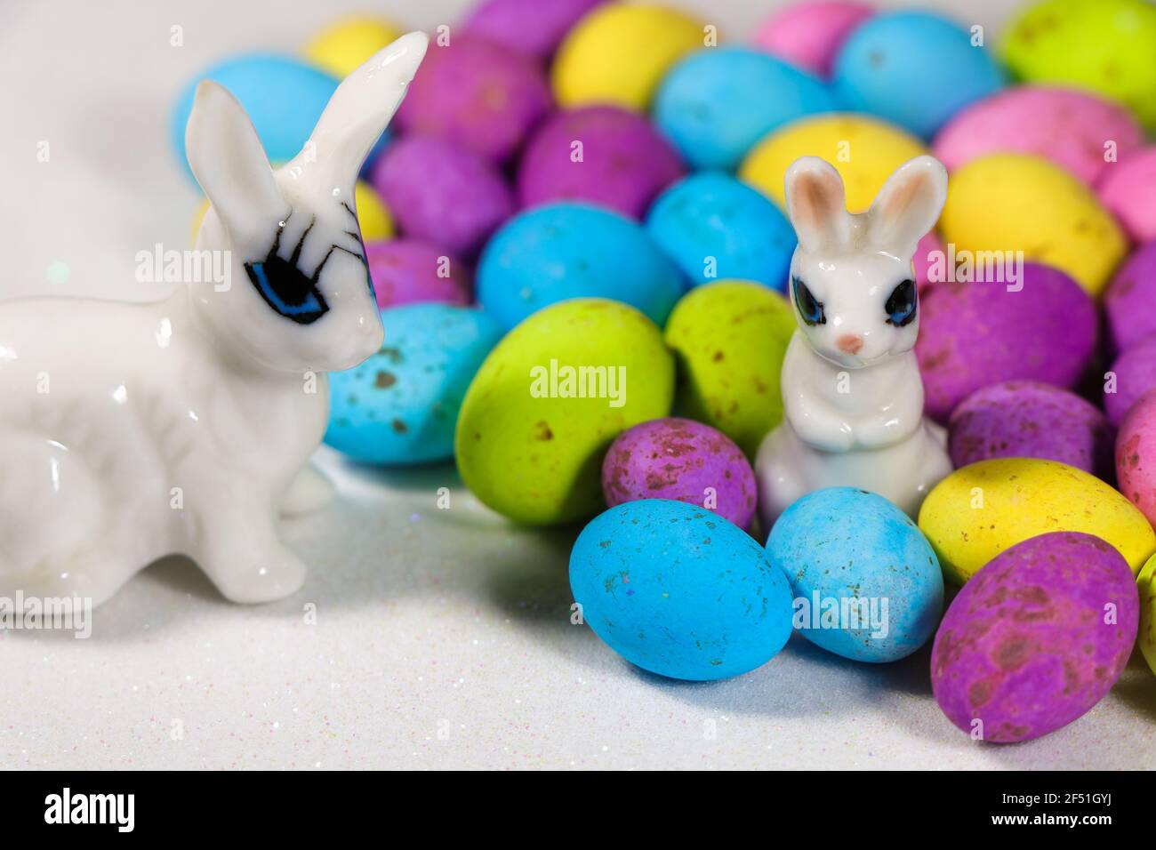 Bunnies With Speckled Candy Eggs On Snowy White Stock Photo