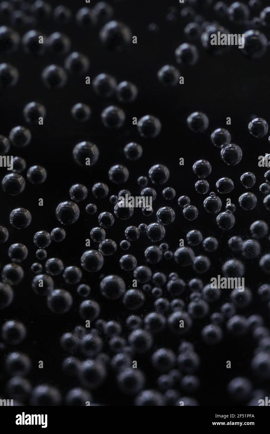 Close-up of gas bubbles in water. Soda water on close-up. Carbonated water on a dark background. Background with bubbles of carbonated water. Stock Photo