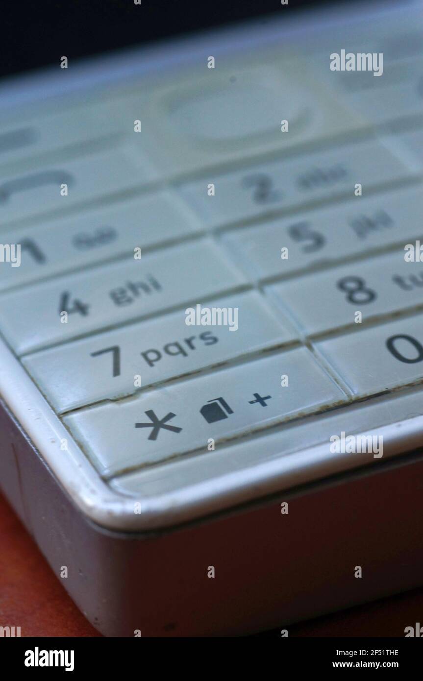 White phone keyboard - old generation. Bright white key with numbers. Keypad for typing messages. Old cell phone. Stock Photo