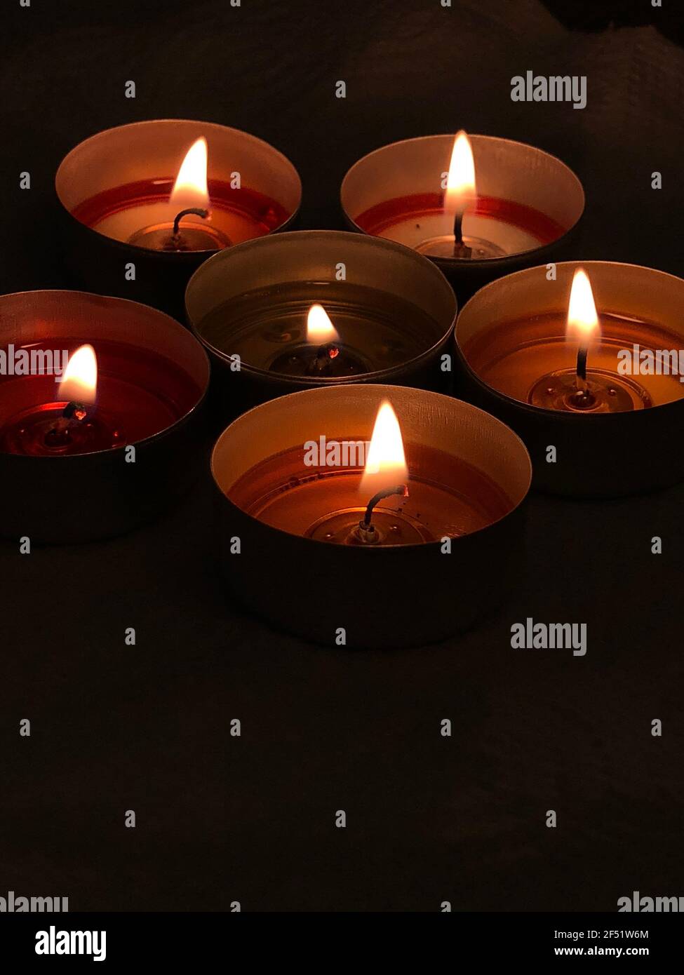 Lighted candles flame. Small heaters in a dark room. A few colored