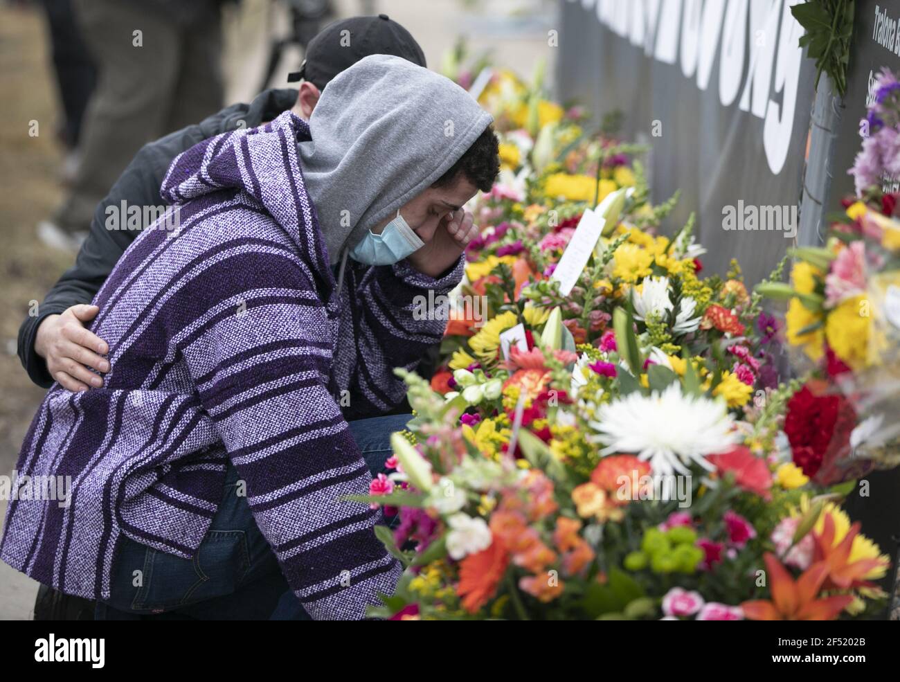 Boulder, United States. 23rd Mar, 2021. A man is comforted after laying flowers outside a King Soopers grocery store where 10 people, including a police officer, were killed in a shooting Monday, in Boulder, Colorado, on Tuesday, March 23, 2021. Police said a suspect, identified as Ahmad Al Aliwi Alissa, was in custody and charged with 10 counts of first-degree murder. Photo by Bob Strong/UPI Credit: UPI/Alamy Live News Stock Photo