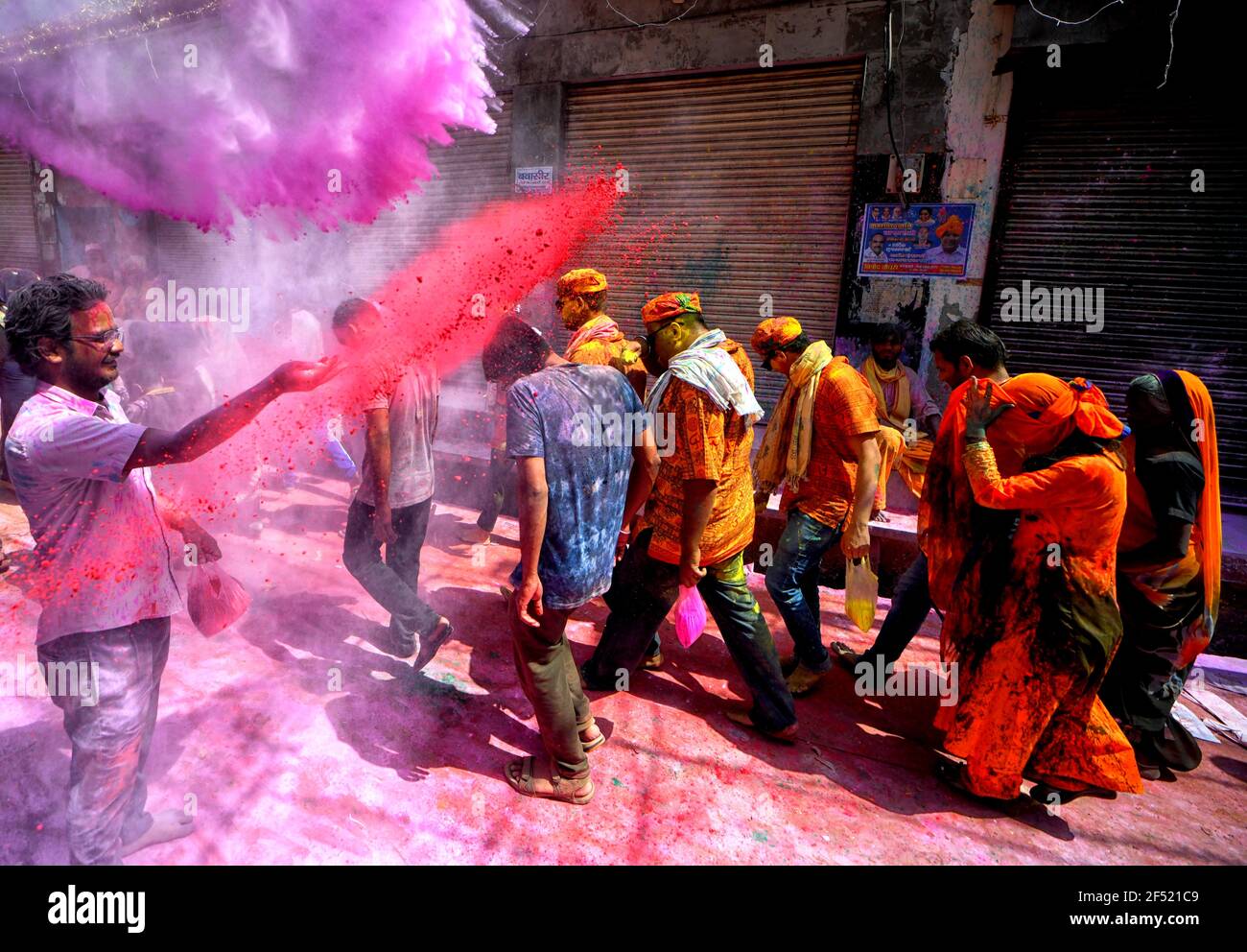 Mathura, India. 23rd Mar, 2021. Devotees seen throwing colourful powder at colleagues during the Lathmar Holi Festival of Barsana.The myth behind this festival is related to Hindu God Lord Krishna who as per local belief came from his hometown Nandgaon to Barsana to tease Radha (a Hindu goddess and a consort of the god Krishna) and her friends. For more than 100 years, women of Barsana still maintaining the ritual. Credit: SOPA Images Limited/Alamy Live News Stock Photo