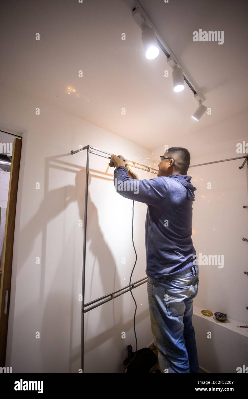 Colombian metal carpenter polishing metal in a dressing room Stock