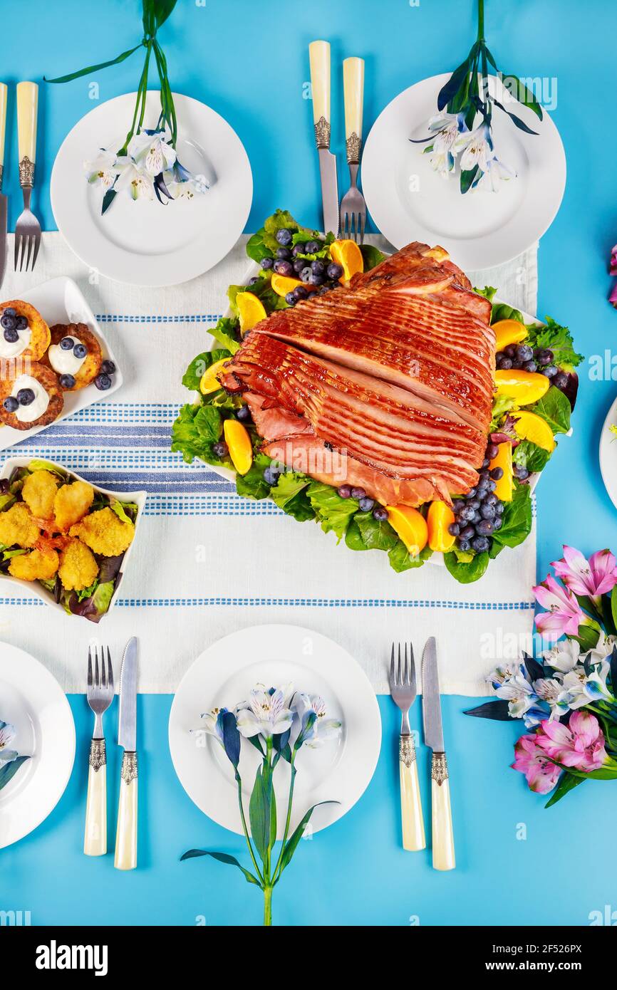 Spiral sliced glazed ham on festive Easter table. Holiday concept. Stock Photo