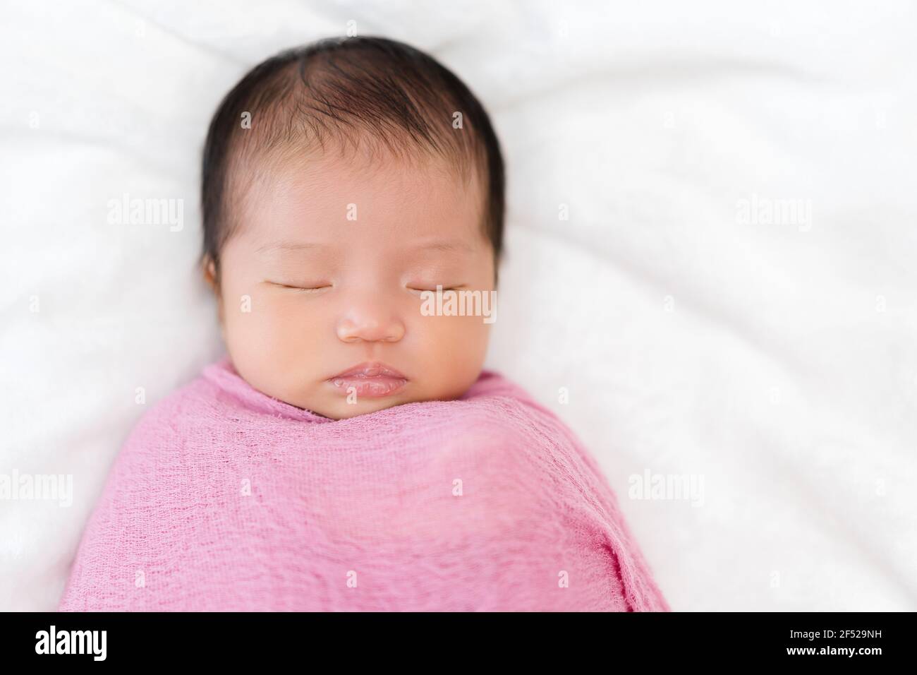newborn baby sleep in pink cloth wrap blanket on a bed Stock Photo Alamy
