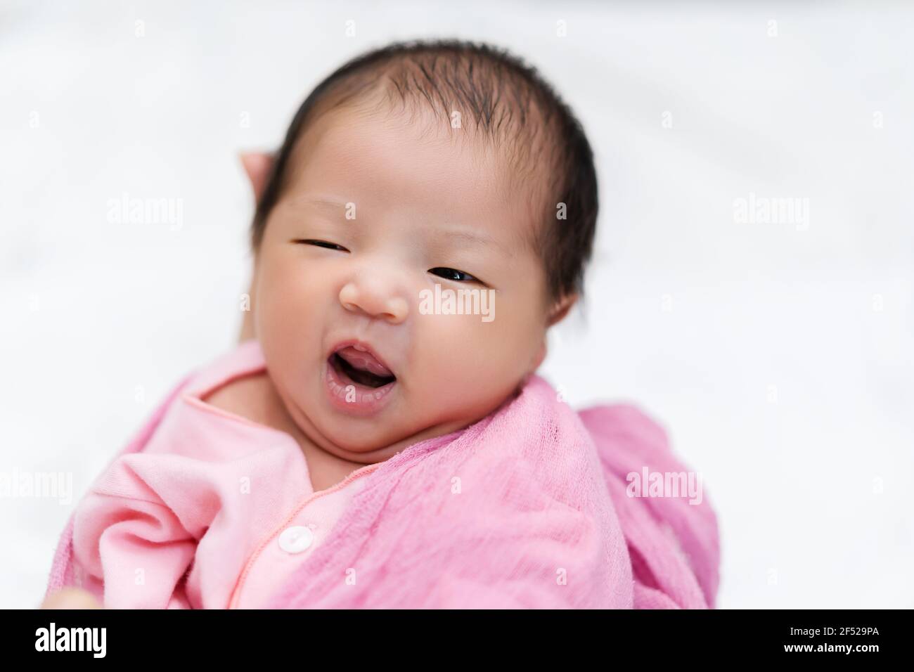 cheerful newborn baby in arm of mother Stock Photo