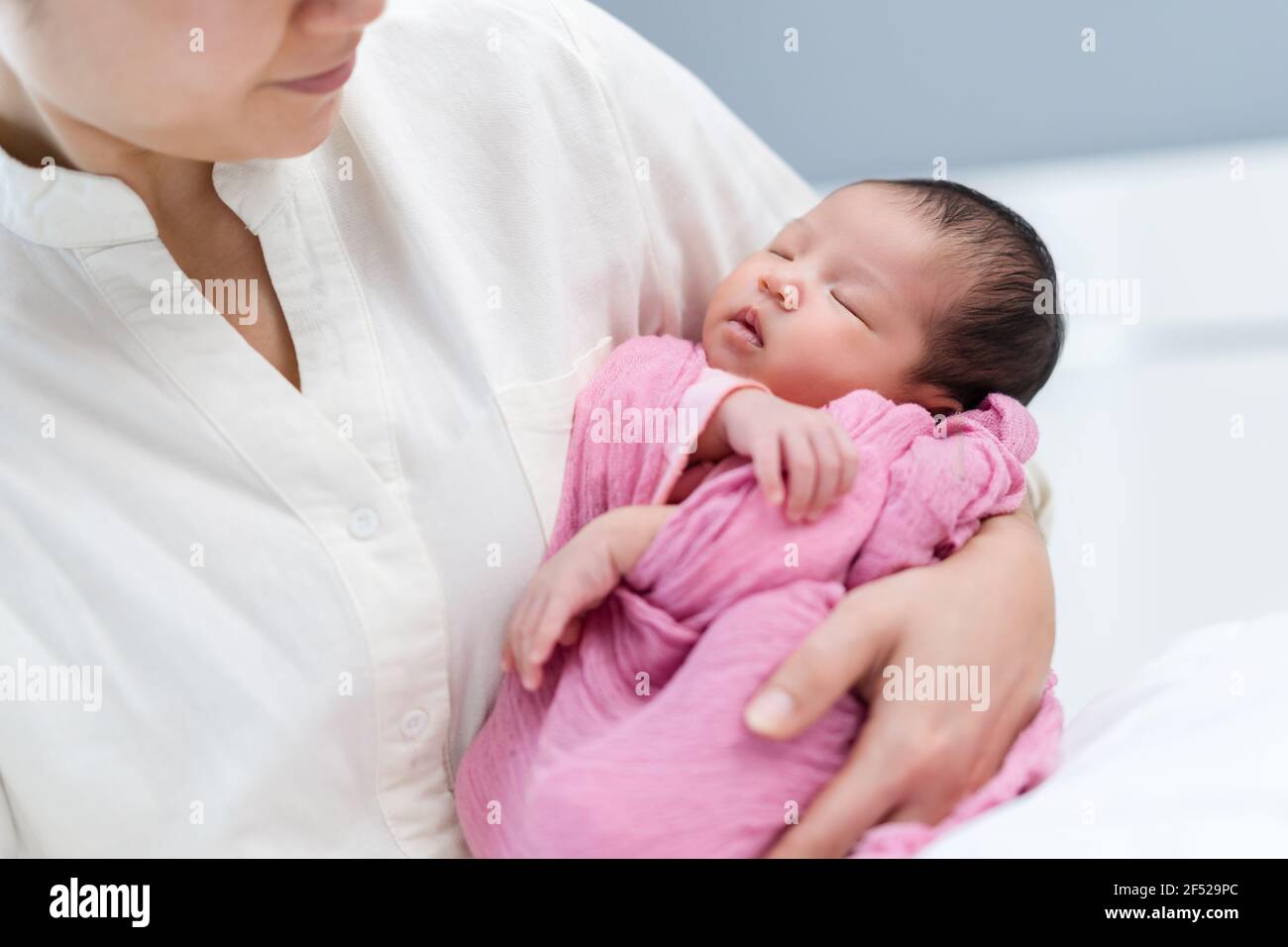 mother holding newborn baby sleeping in her arm Stock Photo Alamy