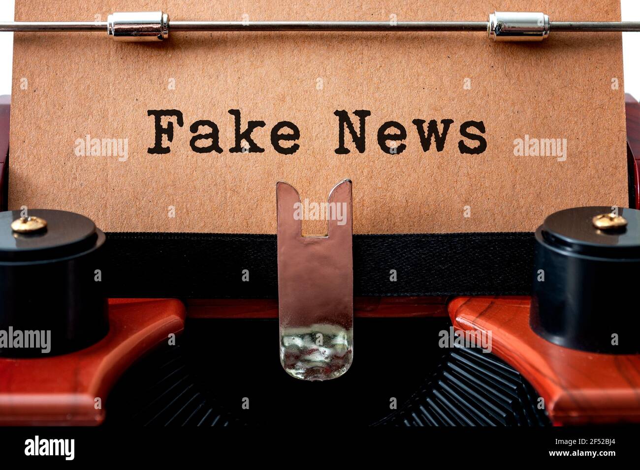 The dishonest media and unreliable newspapers concept with close up on a brown vintage typewriter with the text - fake news - written on yellow grungy Stock Photo