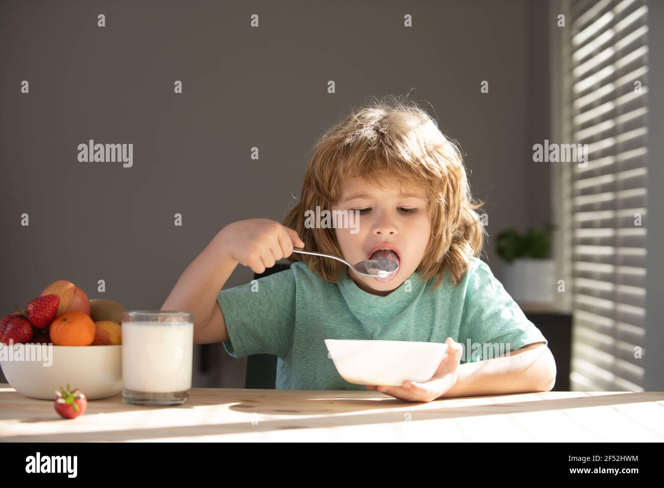 Closeup face of kid eating organic food, yogurt, milk. Child healthy eat. Stock Photo
