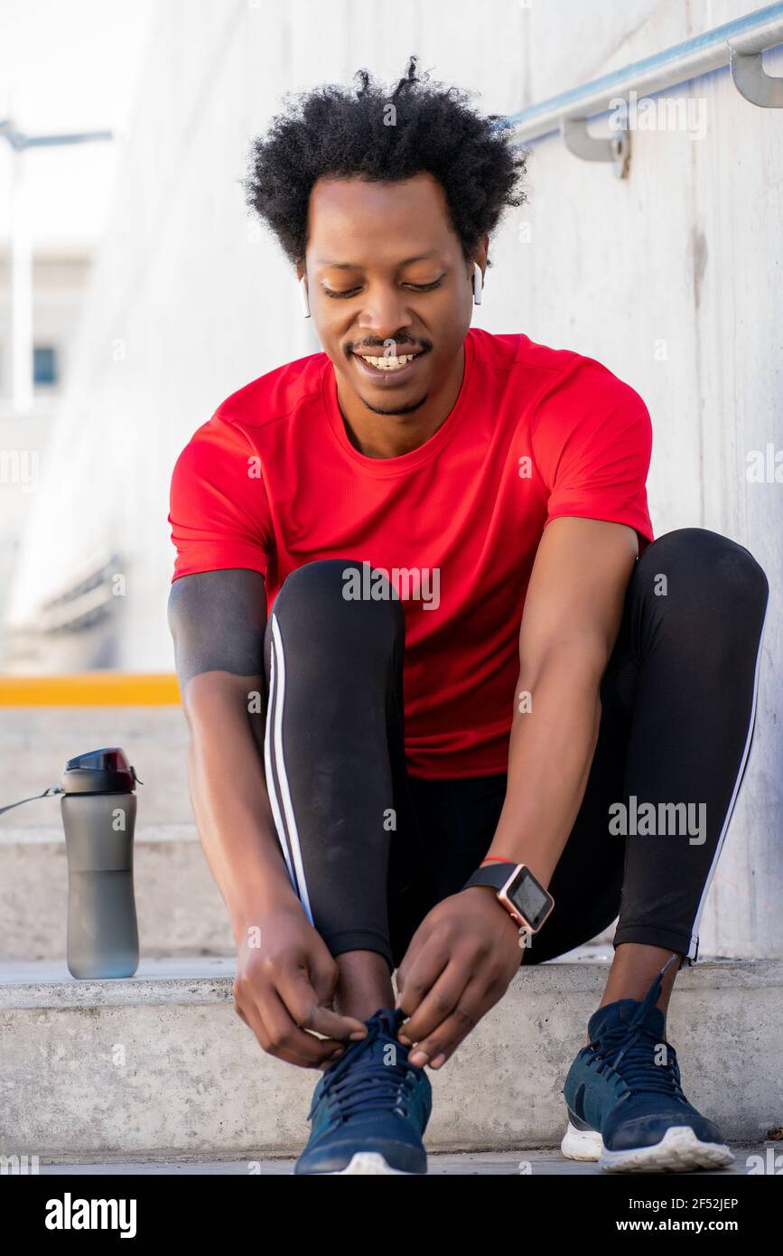 Afro athletic man tying his shoelaces Stock Photo Alamy
