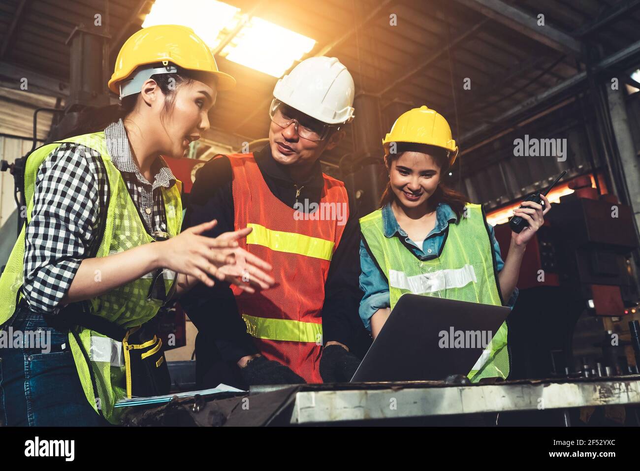 Factory job workers working and discussing manufacturing plan in the