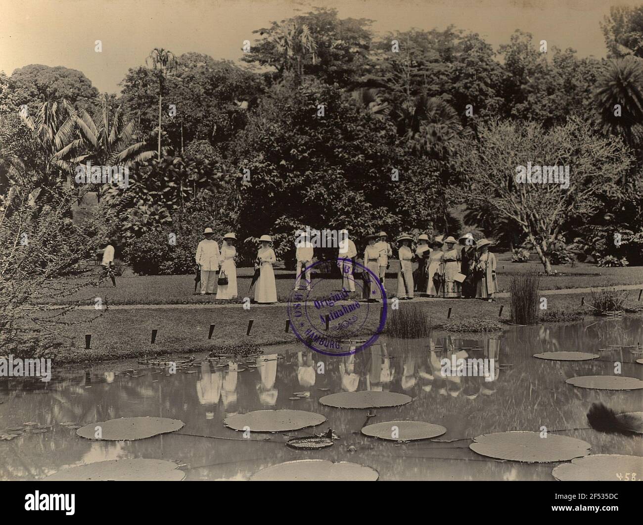 Buitenzorg (Bogor), Java / Indonesia. Botanical Garden (1817, K. G. K. Reinwardt). Tourist group in front of a pond with Victoria Regia Stock Photo