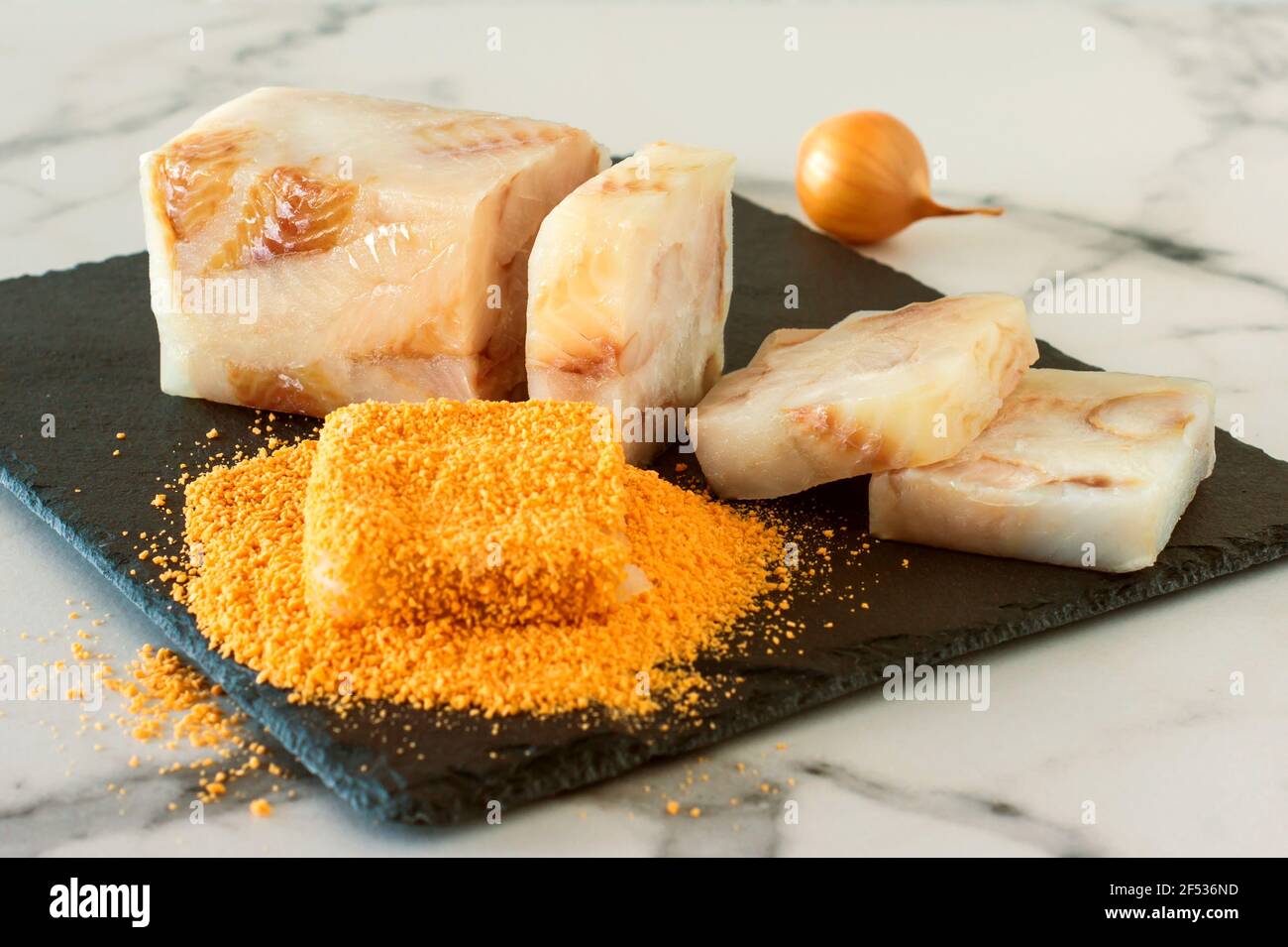 Raw fish blocked in crumbs on a stone board prepared for frying. Stock Photo