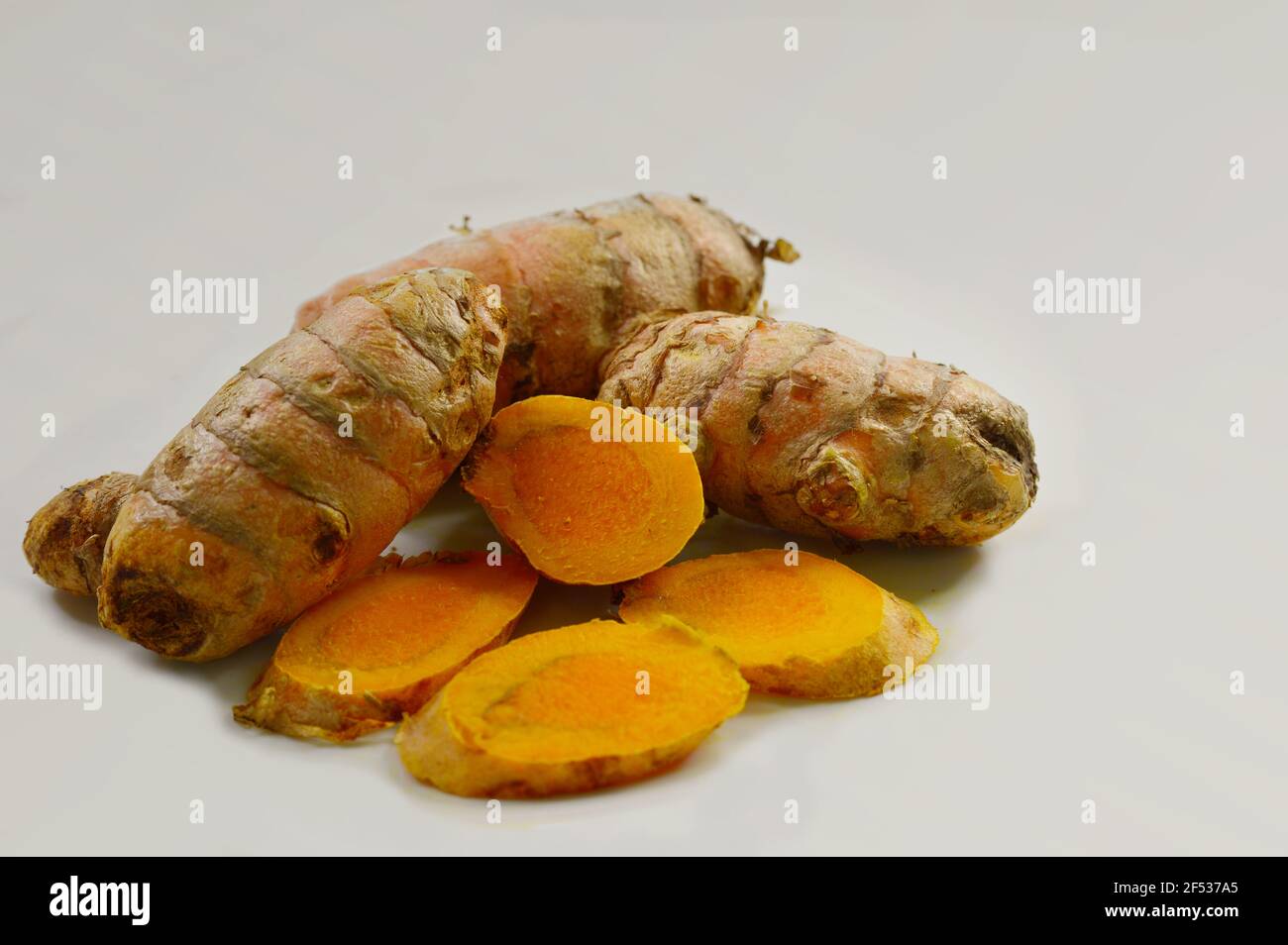 Closeup of slices and whole Turmeric root or rhizome. Native to the