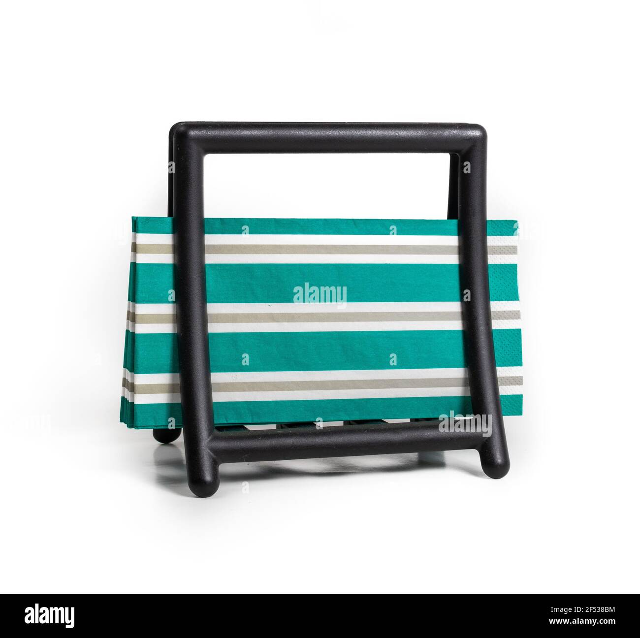Napkin holder with napkins. Simple modern black napkin dispenser with green yellow striped napkins. Used at home, for guest and events. Isolated on wh Stock Photo