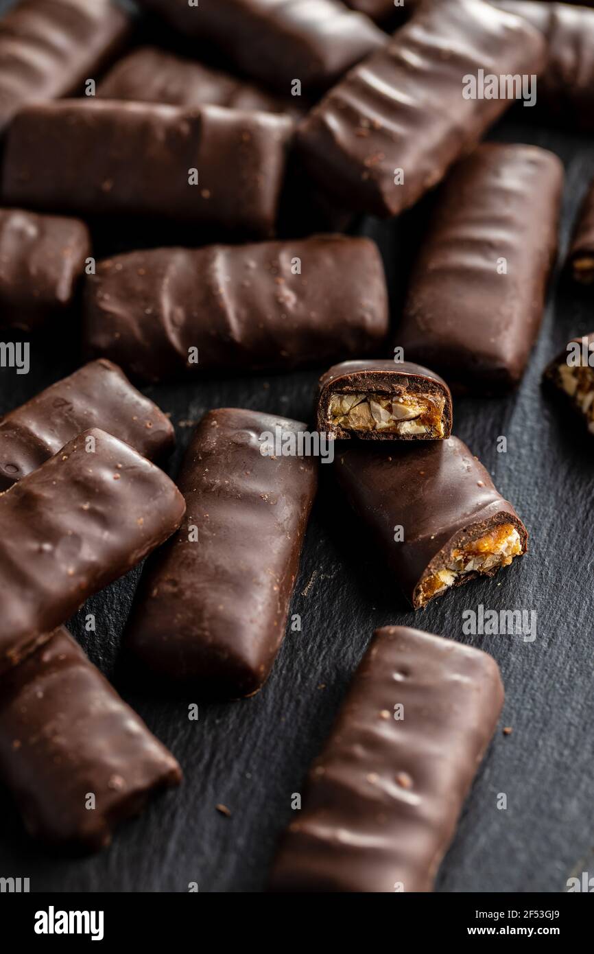 Chocolate bars with nuts filling on black table. Stock Photo