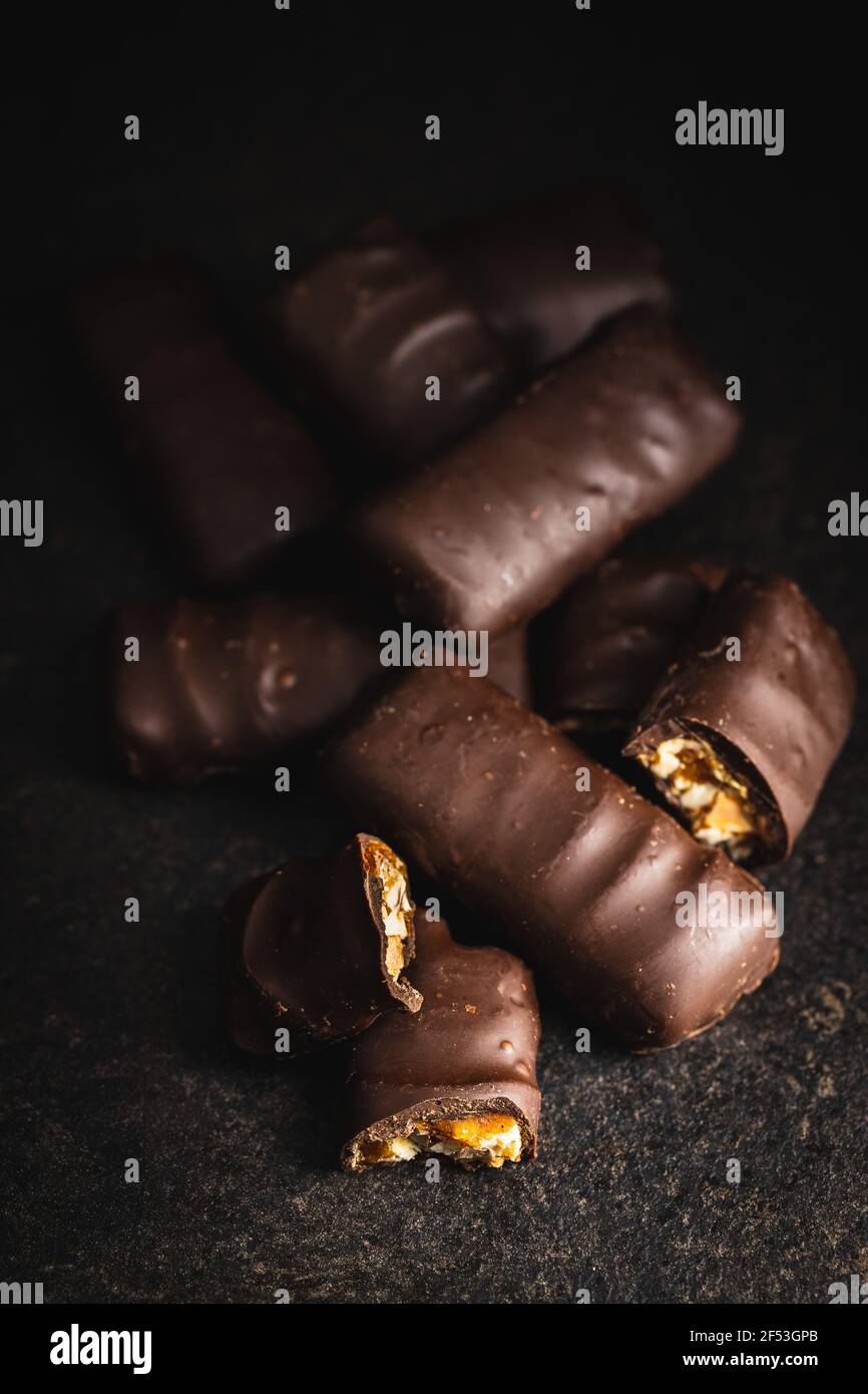 Chocolate bars with nuts filling on black table. Stock Photo