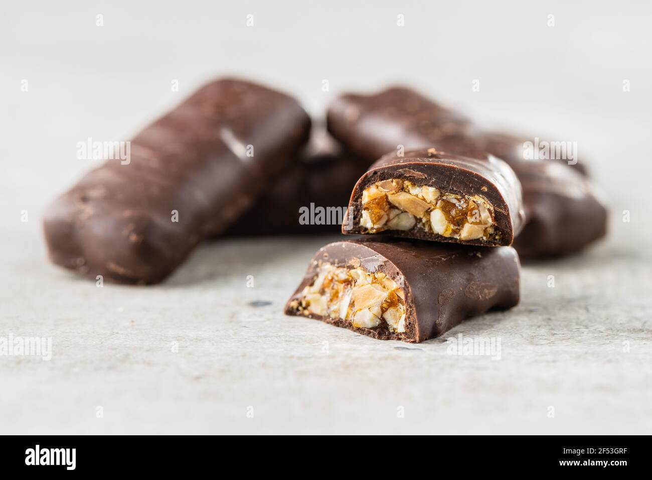 Chocolate bars with nuts filling on white table. Stock Photo