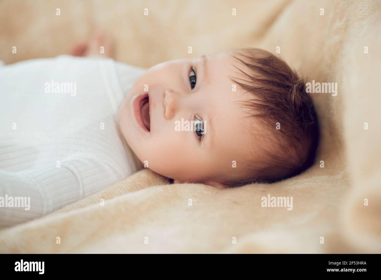 Cheerful smiling kid lying on bed Stock Photo