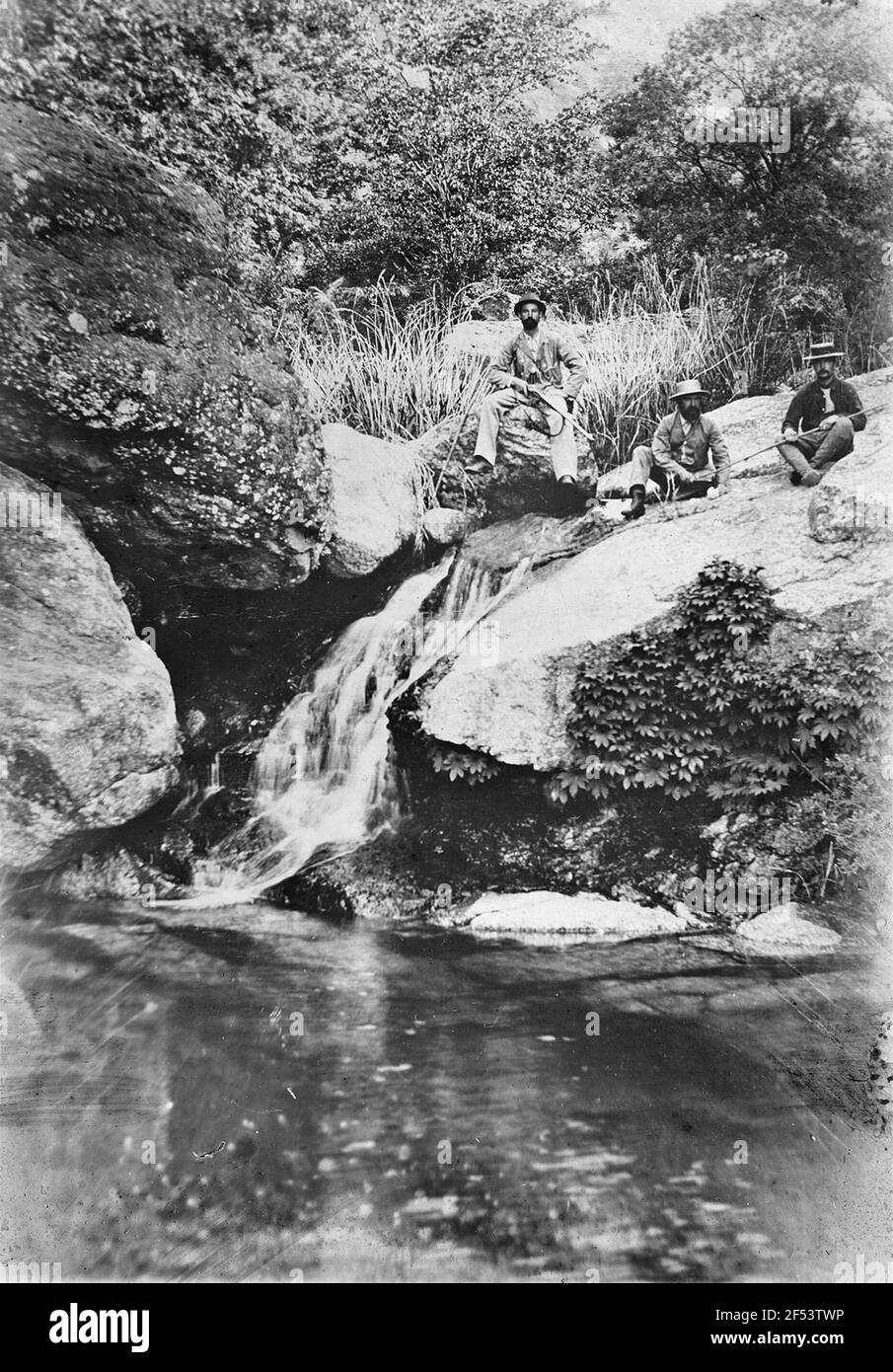 Expedition Manager Bruno Bone Hauer with his brother-in-law Richard Zimmermann (left) and probably Carl Wolter sitting on boulders above a small waterfall, while a hike in the valley of Sang-Wöh-on near the Buddhist monastery Mio-Han-San (north-northeast of Kaechon and near Wol-Lihm) Stock Photo