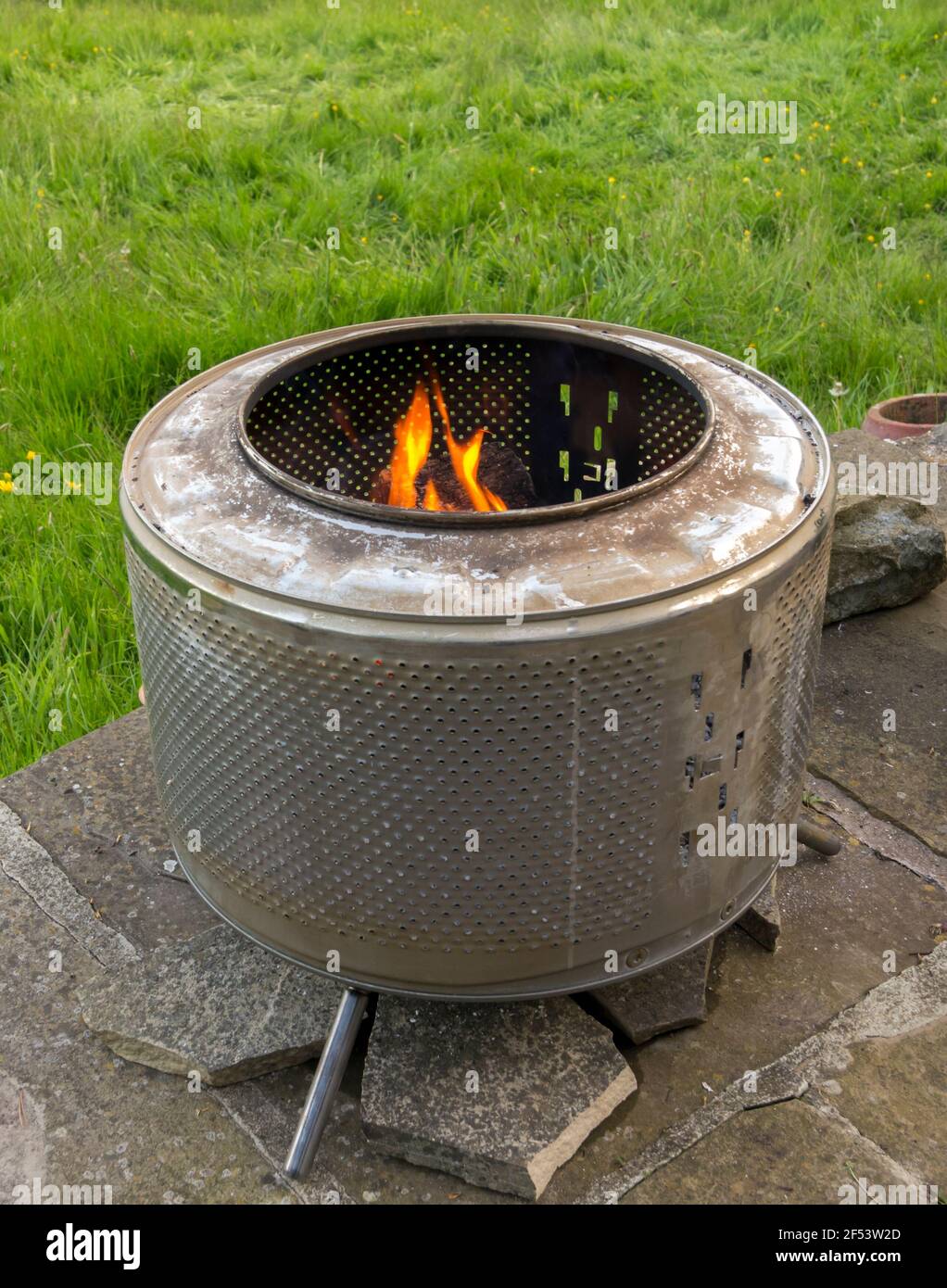 A fire pit made from an old washing machine drum, on a garden patio. UK  Stock Photo - Alamy