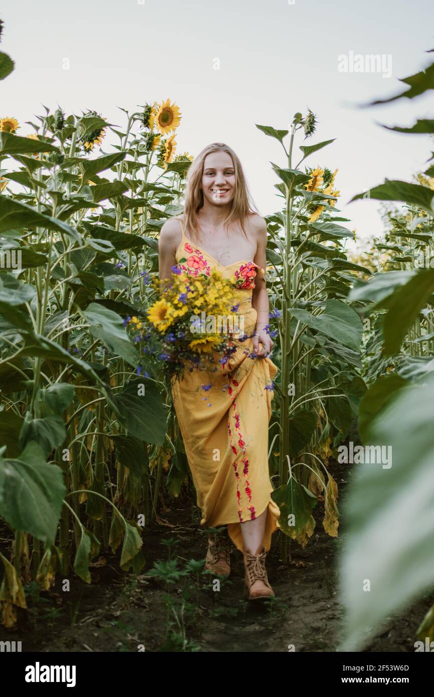 Downshifting, slow living, work life balance, wellness, wellbeing, healthy lifestyle. Young blonde women with wildflowers enjoying moment in nature Stock Photo