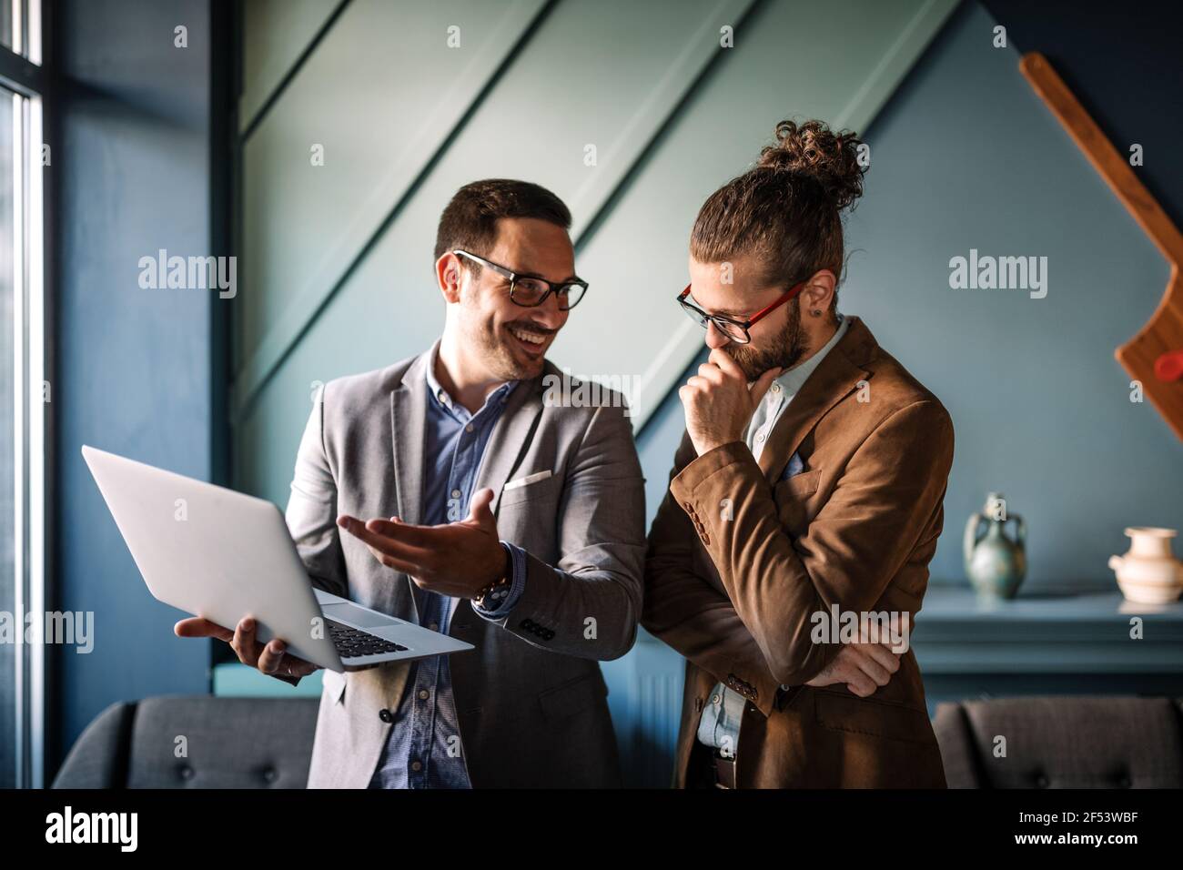 Sharing fresh ideas. Group of young business people in smart casual wear talking and smiling Stock Photo