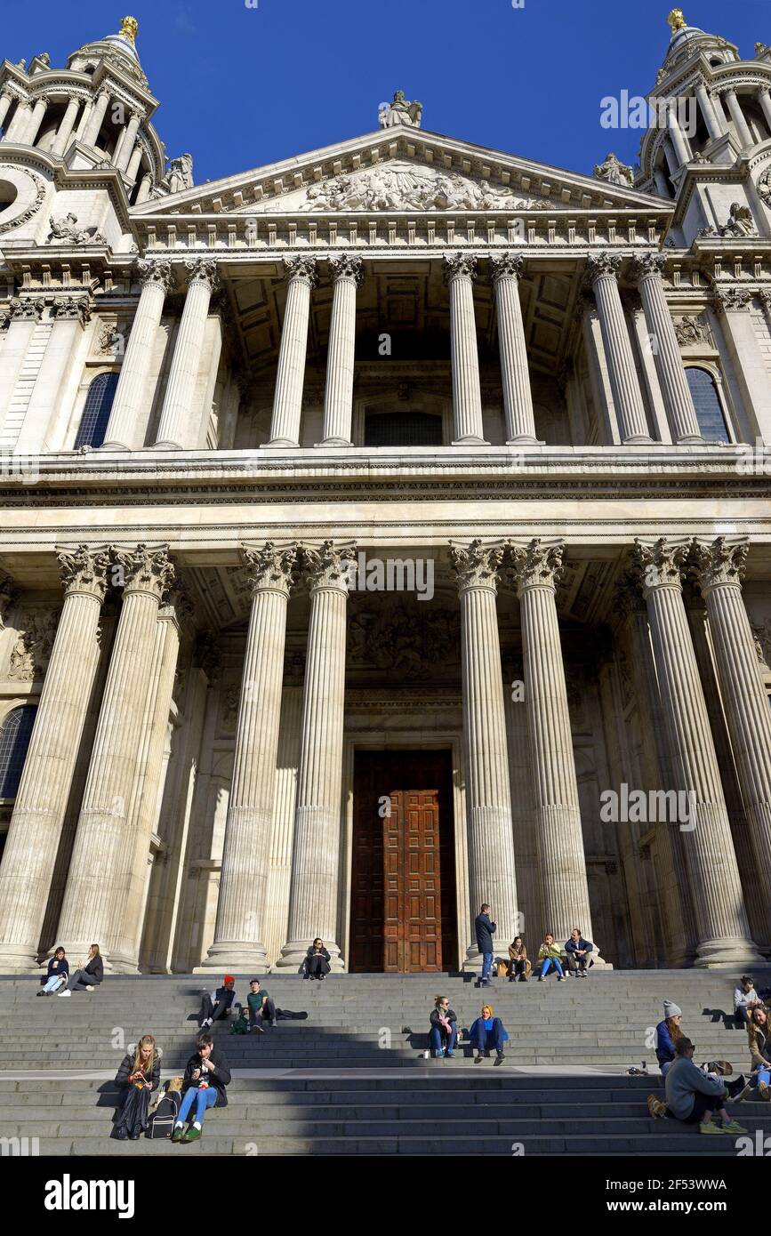 London, England, UK. St Paul's Cathedral - people sitting on the steps during COVID lockdown, March 2021 Stock Photo