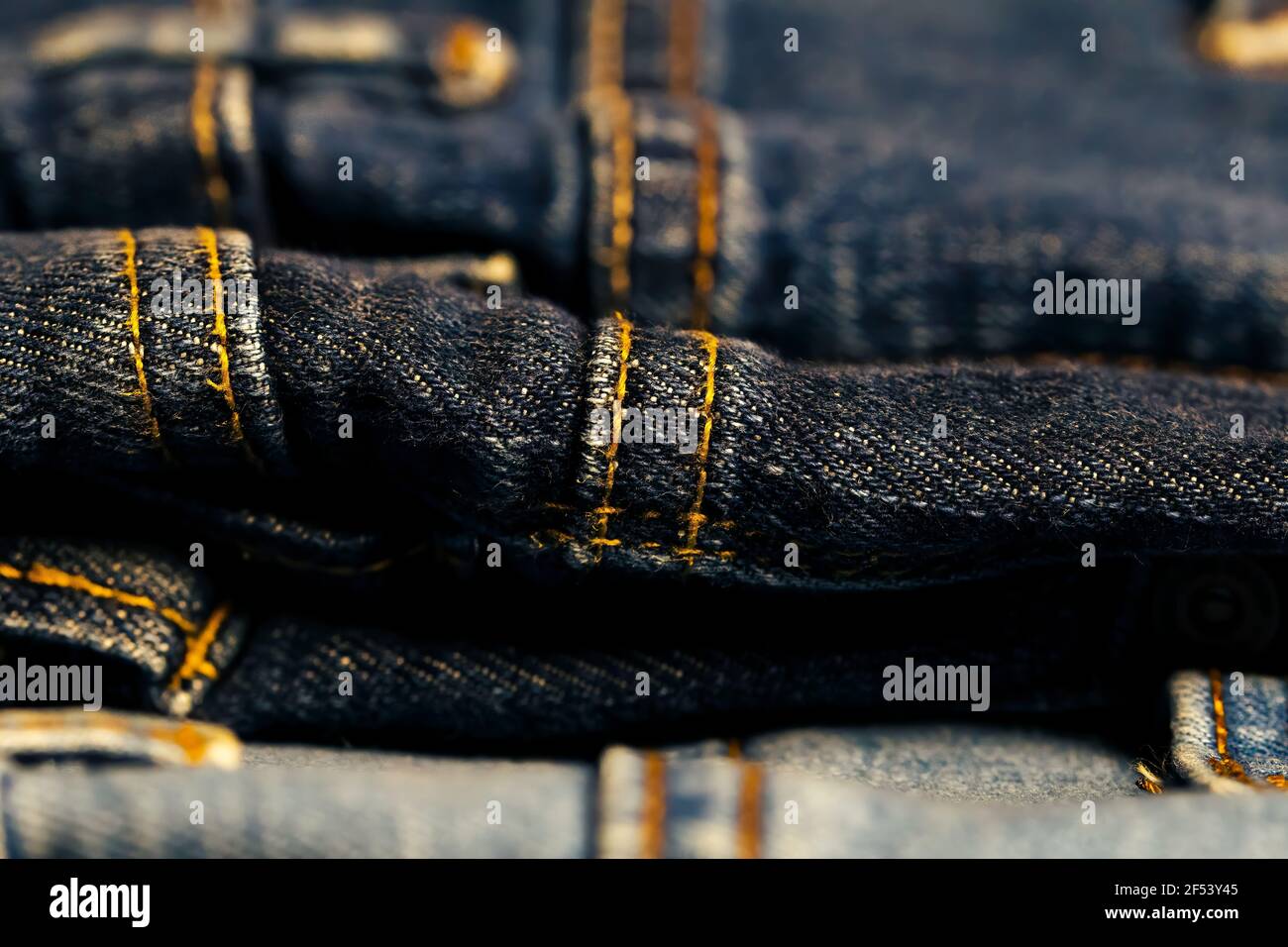Different denim pants with Thick yellow thread. Stock Photo