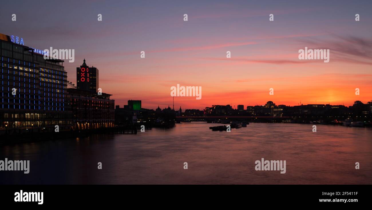 View from Blackfriars bridge across the River Thames at twilight with a sunset reflected in the water with the Oxo Tower and Sea Containers Building Stock Photo
