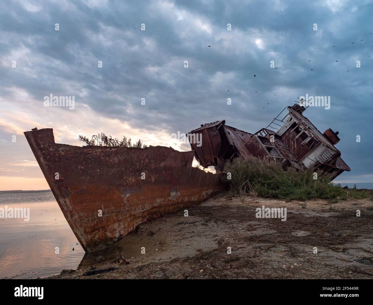 A close-up of an old abandoned ship on the shores of the drying up Aral Sea. Kazakhstan. The ship was sawn for scrap by local residents. Ecological di Stock Photo