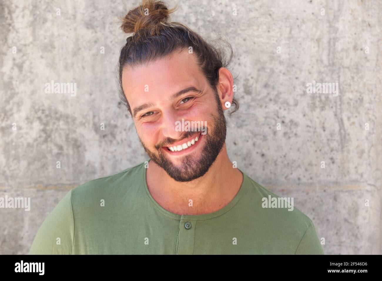 Close up portrait of smiling man with ponytail and beard Stock Photo