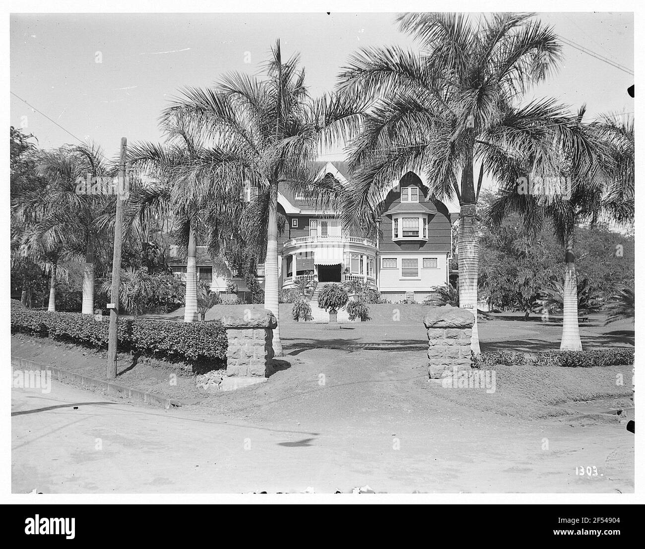 Honolulu (Hawaii). Property with residential building and garden. View with hedge infringement and palm trees Stock Photo