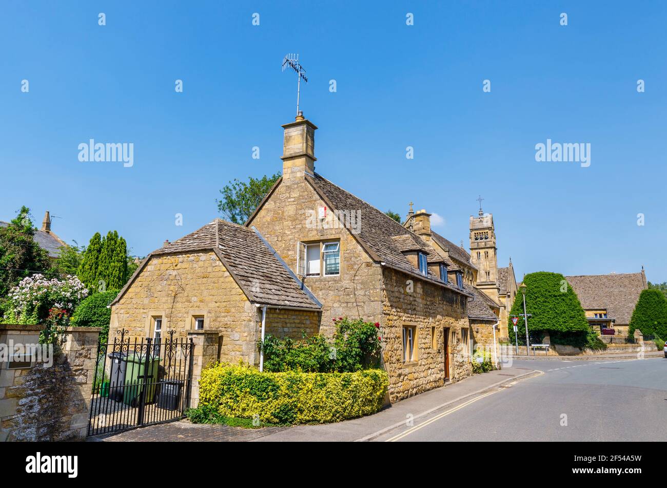 Typical roadside Cotswold stone slate roof houses and St Catharine's Church in Chipping Campden, a small market town in the Cotswolds, Gloucestershire Stock Photo
