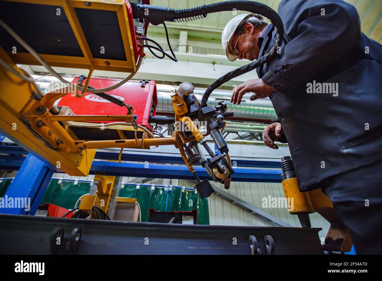Ekibastuz, Pavlodar region, Kazakhstan - May 28, 2012: Rail car-building plant. Welder worker with automatic welding machine. Stock Photo