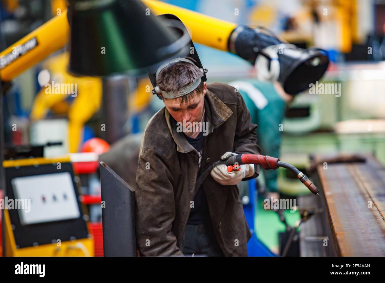 Ekibastuz, Pavlodar region, Kazakhstan - May 28 2012: Train car-building plant. Gas-burner welding of wagon parts. Young welder in protective mask. Stock Photo