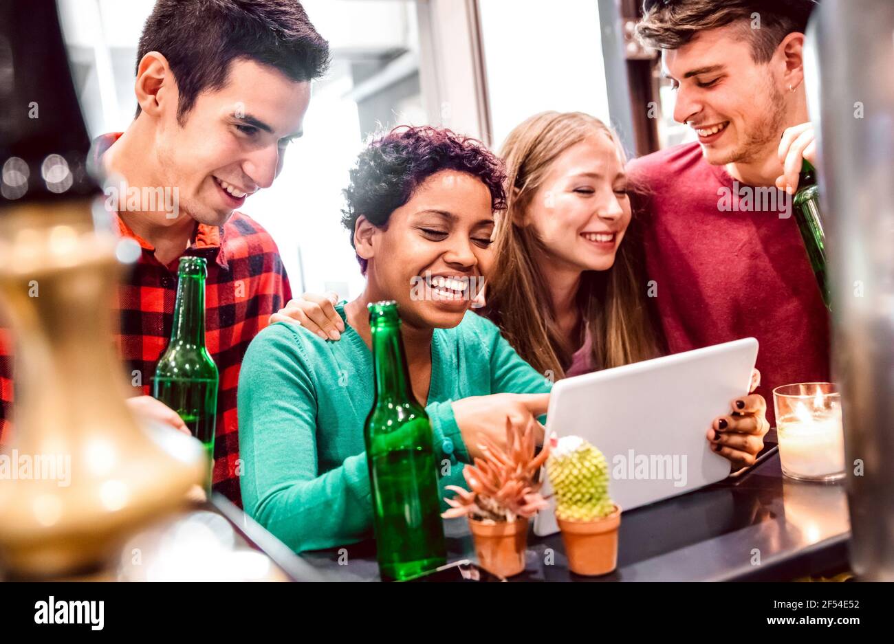 Multiracial milenial friends having fun with laptop at modern coworking space - Technology concept with guys and girls enjoying time together Stock Photo
