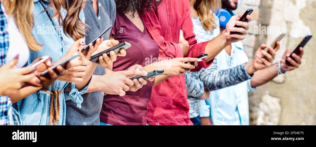 Cropped view on millenial hands using mobile smart phones - People addicted by smartphones - Technology concept with always connected teenagers Stock Photo