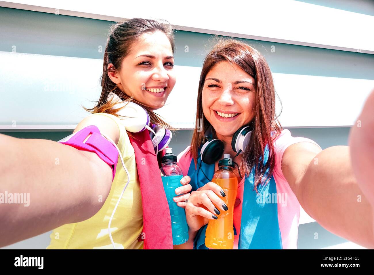 Happy girlfriends taking selfie on break at run training in urban area - Young happy women having fun together with fitness jogging workout Stock Photo