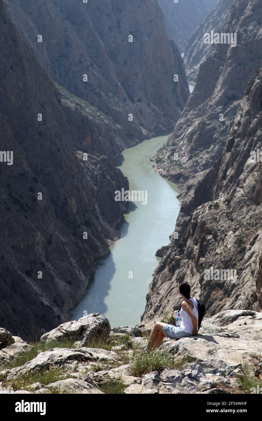 A woman watching the Dark Canyon view at Kemaliye (Egin) in Erzincan, Turkey. Kemaliye is extreme sport center in Eastern Turkey. Stock Photo