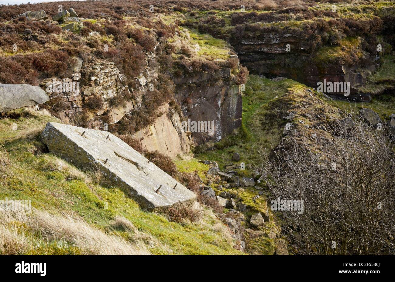 Discarded anchor plate on the side of a disused and unfenced quarry on moorland in Yorkshire Stock Photo