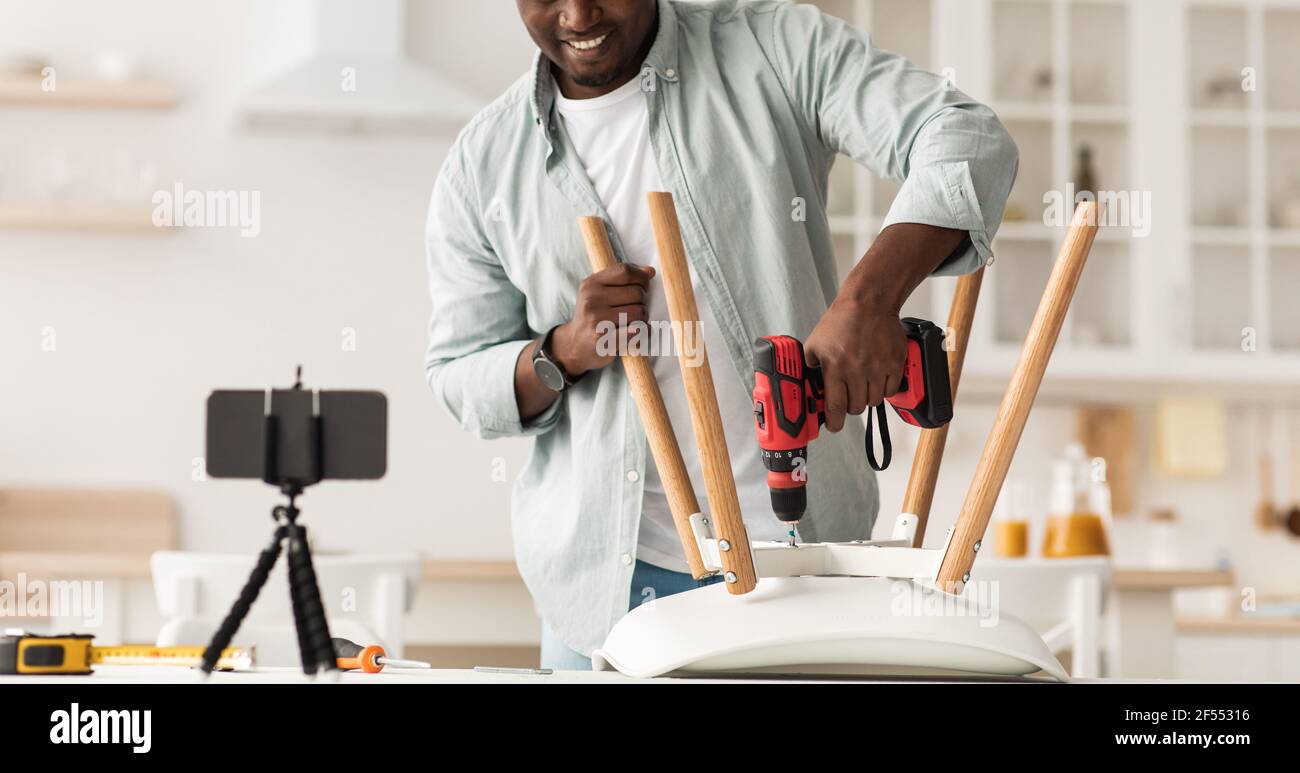 Modern blogger repairman shooting video. African american man making